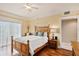 Bedroom featuring hardwood floors, ceiling fan, balcony access, and ensuite bath at 11525 Gulf Blvd # 401, Treasure Island, FL 33706