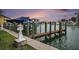 A private boat dock offers waterfront access for residents, with a purple sunset sky at 11525 Gulf Blvd # 401, Treasure Island, FL 33706