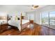 Bright main bedroom featuring hardwood floors, ceiling fan, and sliding glass doors to balcony at 11525 Gulf Blvd # 401, Treasure Island, FL 33706