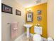 Charming powder room boasts colorful walls, unique mirror, and pedestal sink at 11525 Gulf Blvd # 401, Treasure Island, FL 33706