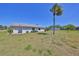 Charming single-story home featuring a well-manicured lawn and a mature palm tree at 124 Gloucester Blvd # 355J, Sun City Center, FL 33573