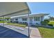 Charming single-story home with well-maintained landscaping, a covered parking area, and a sunny facade at 124 Gloucester Blvd # 355J, Sun City Center, FL 33573