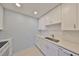 Bright galley kitchen featuring white appliances and shaker cabinets with updated fixtures at 124 Gloucester Blvd # 355J, Sun City Center, FL 33573