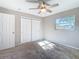 Bedroom featuring carpeted floors, ceiling fan, large closet, and sunlit window at 1247 Holiday Dr, Tarpon Springs, FL 34689