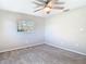 Neutral bedroom featuring carpeted floors, ceiling fan, and a sunlit window at 1247 Holiday Dr, Tarpon Springs, FL 34689