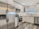Modern kitchen with stainless steel appliances, granite counters, and white cabinetry, offering both style and functionality at 1247 Holiday Dr, Tarpon Springs, FL 34689