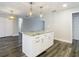 Kitchen island with stone countertop, cabinetry, and modern pendant lighting at 1247 Holiday Dr, Tarpon Springs, FL 34689