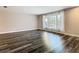 Bright living room with expansive window dressed with flowing curtains, allowing natural light to fill the space, showcasing modern flooring at 1247 Holiday Dr, Tarpon Springs, FL 34689