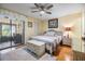 Comfortable bedroom with ceiling fan and sliding glass doors to an outdoor patio at 1333 Shady Pine Way # B, Tarpon Springs, FL 34688