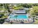 Inviting community pool and clubhouse with lounge chairs and a serene lake backdrop at 1333 Shady Pine Way # B, Tarpon Springs, FL 34688