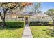 Inviting townhome exterior with a well-kept lawn and a paved walkway, offering a cozy entrance with lots of curb appeal at 1333 Shady Pine Way # B, Tarpon Springs, FL 34688