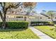 Well-maintained townhome exterior featuring manicured landscaping and a sidewalk leading to the entrance, providing curb appeal at 1333 Shady Pine Way # B, Tarpon Springs, FL 34688
