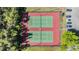 Aerial view of two well-maintained tennis courts surrounded by lush greenery at 1333 Shady Pine Way # B, Tarpon Springs, FL 34688