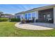 Home exterior showcases a paver patio, screened in porch, and manicured lawn at 14885 Caravan Ave, Odessa, FL 33556