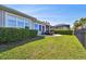 Spacious backyard with lush green lawn, manicured hedges, and a screened pool at 14885 Caravan Ave, Odessa, FL 33556