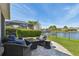 Outdoor patio with comfortable wicker furniture, lush greenery, and serene lake view at 14885 Caravan Ave, Odessa, FL 33556