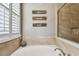 Bathroom with a soaking tub and stylish shower featuring travertine tile surround at 14885 Caravan Ave, Odessa, FL 33556
