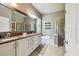 Bathroom featuring double sinks, soaking tub, and glass-enclosed shower at 14885 Caravan Ave, Odessa, FL 33556