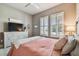 A comfortable bedroom features a ceiling fan, plush carpet, and stylish dresser with a TV at 14885 Caravan Ave, Odessa, FL 33556