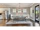 Dining area features dark wood floors, a modern chandelier, and a long, decorative table with seating at 14885 Caravan Ave, Odessa, FL 33556