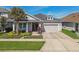 Well-maintained single-Gathering home with lush landscaping, stone accents, and a two-car garage at 14885 Caravan Ave, Odessa, FL 33556