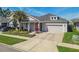 Charming single Gathering home with beautiful landscaping, covered front porch, and a two-car garage at 14885 Caravan Ave, Odessa, FL 33556
