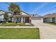 Charming single-Gathering home featuring a well-manicured lawn, landscaping, and attached garage at 14885 Caravan Ave, Odessa, FL 33556