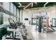A modern gym with treadmills, weights, and a punching bag has an industrial-style ceiling and large windows overlooking the grounds at 14885 Caravan Ave, Odessa, FL 33556