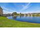 Serene lake view with grassy shoreline, picturesque bridge and various home exteriors along the water at 14885 Caravan Ave, Odessa, FL 33556