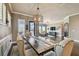 Open floor plan with a dining area that has modern light fixtures, lots of windows, and dark wood floors at 14885 Caravan Ave, Odessa, FL 33556
