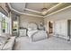 Spacious main bedroom featuring a tray ceiling, chandelier, sitting area, and elegant furnishings at 14885 Caravan Ave, Odessa, FL 33556