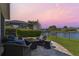 Relaxing patio with waterfront view, outdoor seating, and screened-in lanai beyond at 14885 Caravan Ave, Odessa, FL 33556