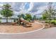 A charming playground with a slide and climbing net, surrounded by lush landscaping, promises endless fun for children at 14885 Caravan Ave, Odessa, FL 33556