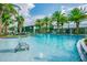 Resort-style pool with palm trees, lounge chairs, and turquoise water at 14885 Caravan Ave, Odessa, FL 33556