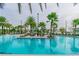 Resort-style pool with palm trees, lounge chairs, in-pool tables, and turquoise water at 14885 Caravan Ave, Odessa, FL 33556