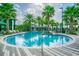 Resort-style pool with palm trees, lounge chairs, and turquoise water at 14885 Caravan Ave, Odessa, FL 33556