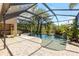 The screened-in pool, set in a stone patio, is surrounded by tropical landscaping at 19352 Otters Wick Way, Land O Lakes, FL 34638