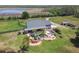 Aerial view showcases a property with a custom pool, surrounded by lush landscaping and acreage at 19530 Barrie Acres Trl, Odessa, FL 33556