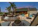 Paver patio with outdoor fire pit, pool, lounge chairs, and tropical landscaping for luxurious outdoor living at 19530 Barrie Acres Trl, Odessa, FL 33556