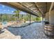 Backyard patio features a rock-lined pool area, covered patio, and scenic views of the natural landscape at 19530 Barrie Acres Trl, Odessa, FL 33556