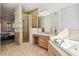Bright bathroom includes tiled floors, soaking tub, glass shower, and a vanity at 19530 Barrie Acres Trl, Odessa, FL 33556