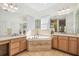 Spacious bathroom featuring tiled floors, a soaking tub, double vanity, and bright lighting at 19530 Barrie Acres Trl, Odessa, FL 33556