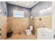 Bathroom showcasing neutral tile, blue walls, and a window above toilet for natural lighting at 19530 Barrie Acres Trl, Odessa, FL 33556