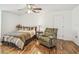 Cozy bedroom with neutral-toned bedding, ceiling fan and wood floors at 19530 Barrie Acres Trl, Odessa, FL 33556