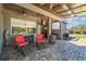 Relaxing covered patio with seating, outdoor cooking area, and views of the serene backyard at 19530 Barrie Acres Trl, Odessa, FL 33556