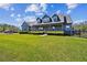 Beautiful two-story home featuring an expansive lawn and a welcoming front porch under bright blue skies at 19530 Barrie Acres Trl, Odessa, FL 33556