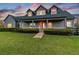 Inviting home featuring a charming porch, a brick walkway, and a lush green lawn at sunset at 19530 Barrie Acres Trl, Odessa, FL 33556