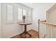 Hallway with wood floors, white walls, window with shutters and table lamp at 19530 Barrie Acres Trl, Odessa, FL 33556