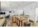 Open kitchen with an island, breakfast bar, wood floors, and stainless steel appliances at 19530 Barrie Acres Trl, Odessa, FL 33556