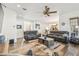Open-concept living room with a fireplace, ceiling fan, wood-look flooring, and access to the kitchen at 19530 Barrie Acres Trl, Odessa, FL 33556